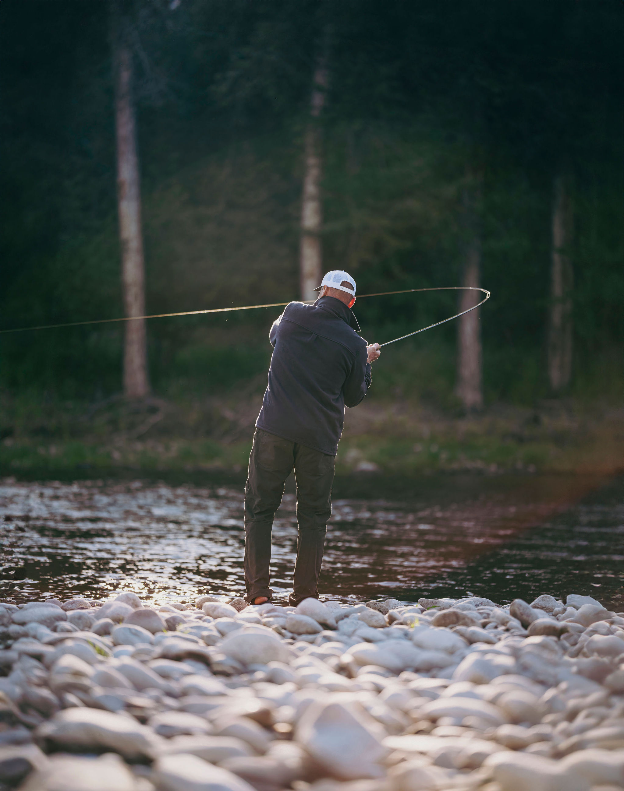 Fly casting from the rocky shore at golden hour