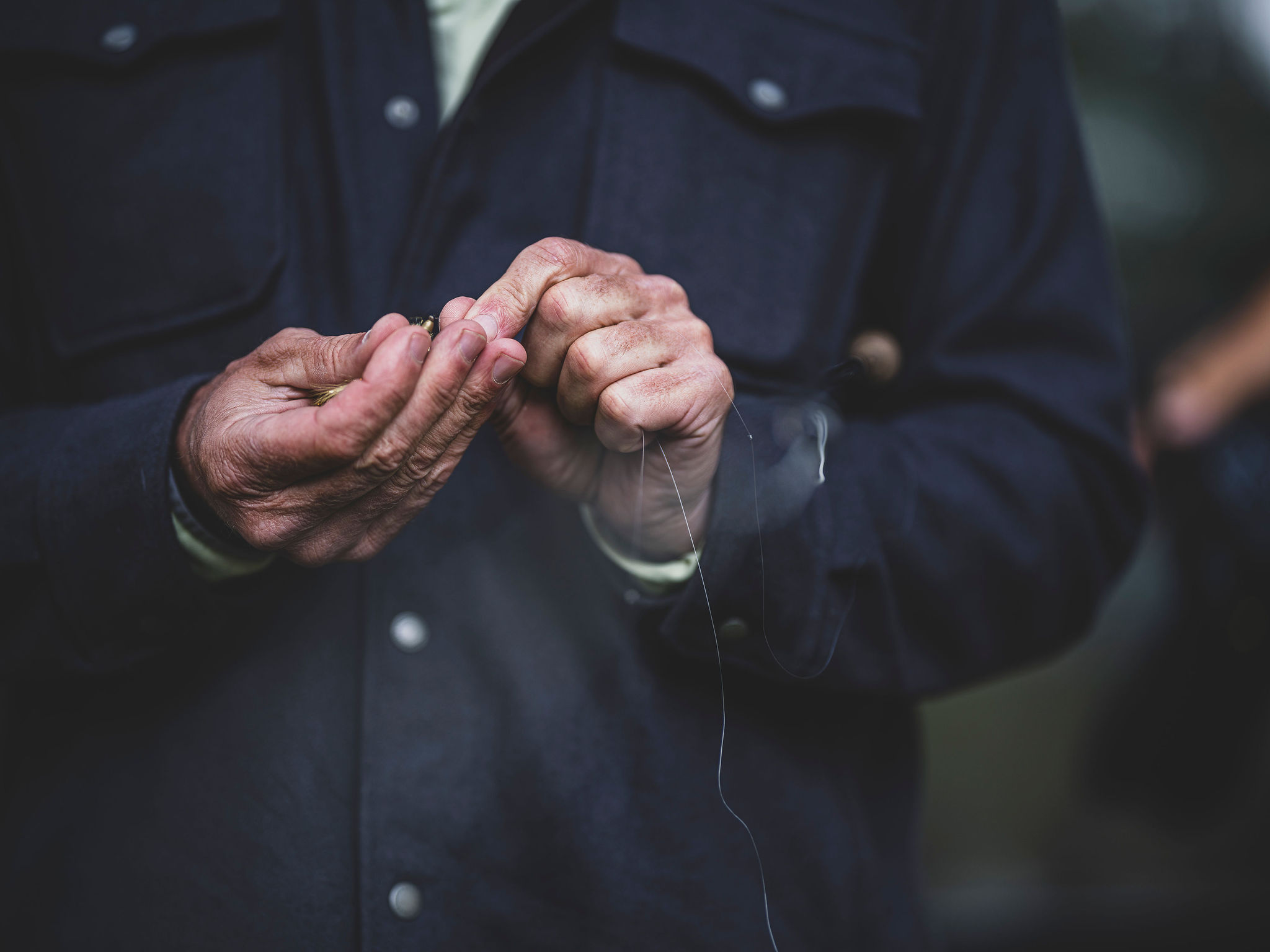 Tying a fly by hand on the river