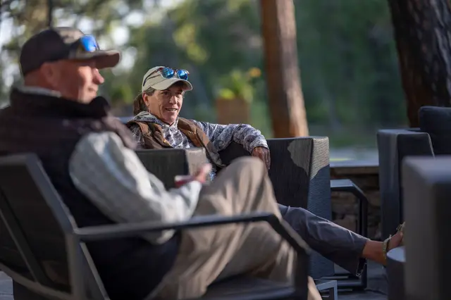 Guests relaxing on the lodge patio after a day of fishing